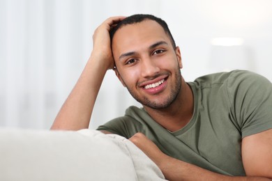 Photo of Portrait of smiling African American man on sofa at home