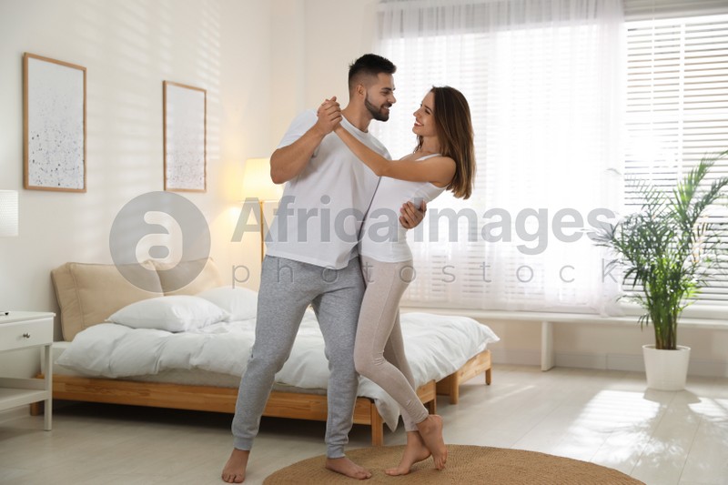 Photo of Lovely young couple dancing in bedroom at home
