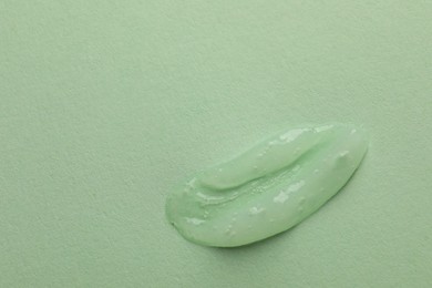 Photo of Sample of face gel on light green background, top view. Space for text