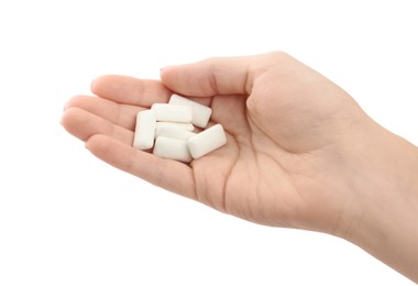 Woman holding pile of chewing gum pieces on white background, closeup