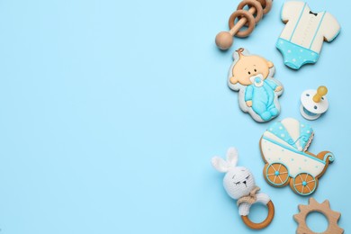 Photo of Baby shower cookies and toys on turquoise background, flat lay. Space for text