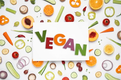 Paper card with word Vegan, fresh vegetables and fruits on white background, flat lay
