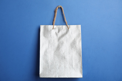Silver shopping paper bag on blue background