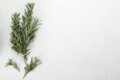 Bunch of fresh rosemary on white table, flat lay. Space for text