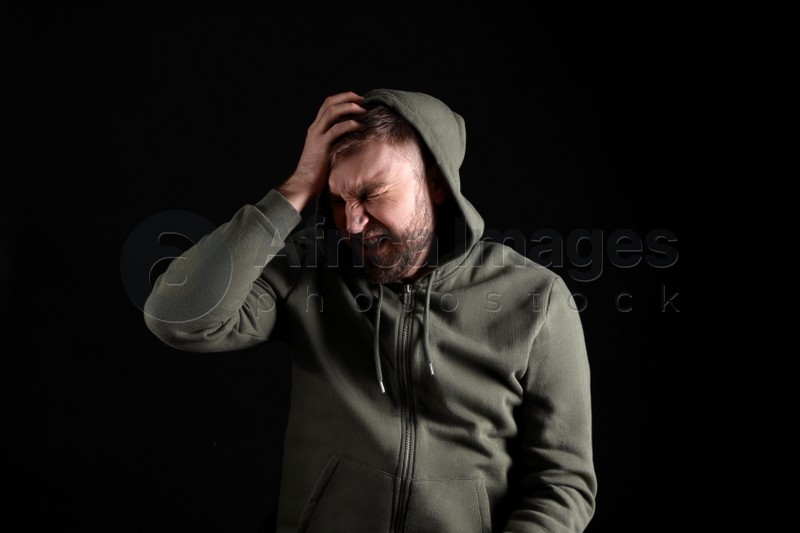 Portrait of emotional young man on black background. Personality concept