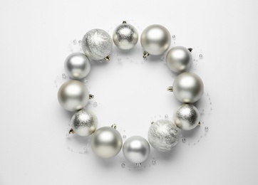 Beautiful festive wreath made of silver Christmas balls on white background, top view