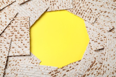 Frame of traditional matzos on yellow background, flat lay. Space for text