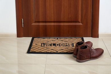 Brown classic shoes on welcome doormat in hall