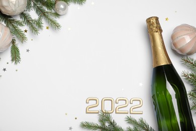 Happy New Year 2022! Flat lay composition with bottle of sparkling wine on light background, space for text