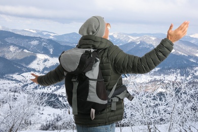 Image of Tourist with travel backpack enjoying mountain landscape during vacation trip
