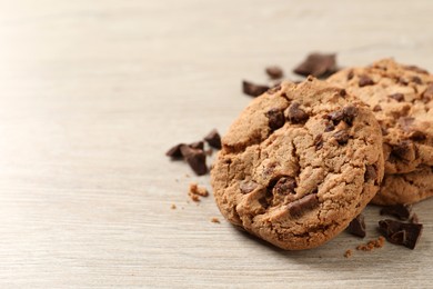 Photo of Delicious chocolate chip cookies on wooden table, closeup. Space for text