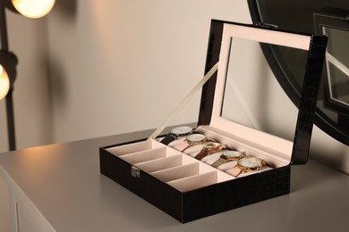 Elegant jewelry box with expensive wristwatches on grey table indoors