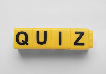 Yellow cubes with word Quiz on white background, top view