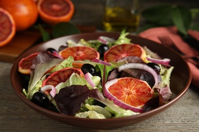 Bowl of delicious sicilian orange salad on wooden table, closeup