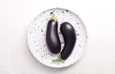 Raw ripe eggplants on light table, top view