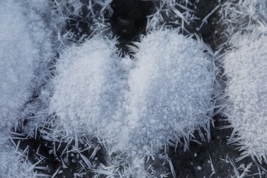 Photo of Heart made of hoarfrost crystals on icy surface, closeup view