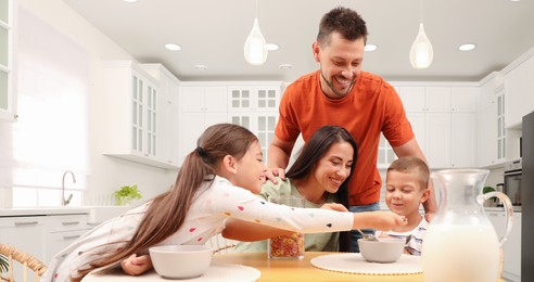 Happy family with children having fun during breakfast at home. Banner design