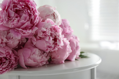 Bunch of beautiful peonies on table indoors, closeup