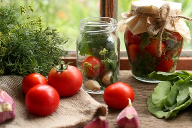 Photo of Glass jars, fresh vegetables and herbs on wooden table indoors. Pickling recipe