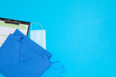 Photo of Medical uniform, clipboard and protective mask on light blue background, flat lay. Space for text