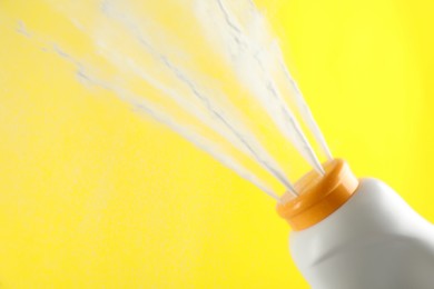Photo of Scattering of dusting powder on yellow background