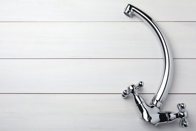 Double handle water tap on white wooden table, top view. Space for text