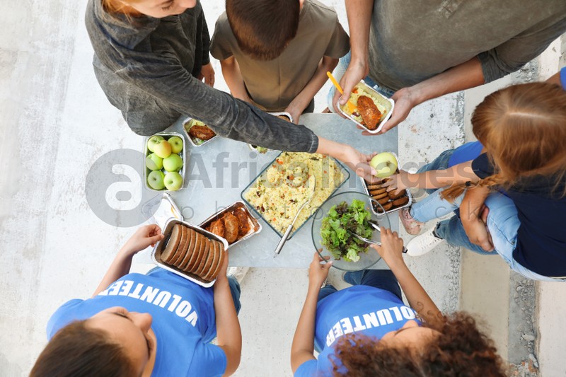 Volunteers serving food to poor people outdoors, top view