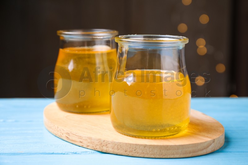 Photo of Tasty aromatic honey on light blue wooden table