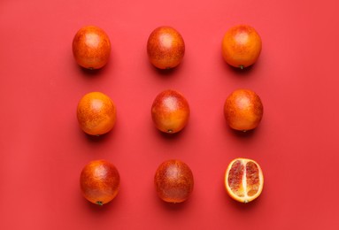 Many ripe sicilian oranges on red background, flat lay