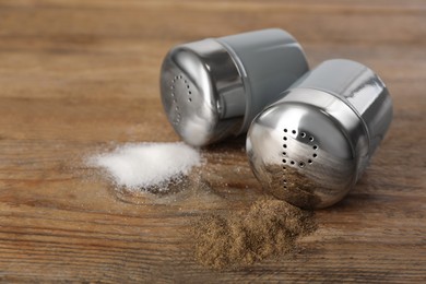 Salt and pepper shakers on wooden table, closeup