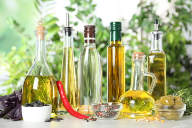 Different sorts of cooking oil in bottles and ingredients on light table
