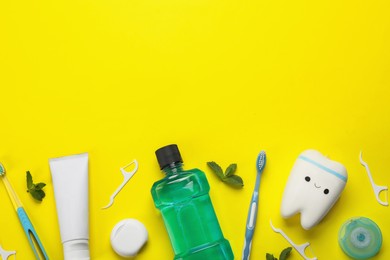 Flat lay composition with mouthwash and other oral hygiene products on yellow background. Space for text