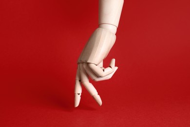 Wooden hand model on red background. Mannequin part