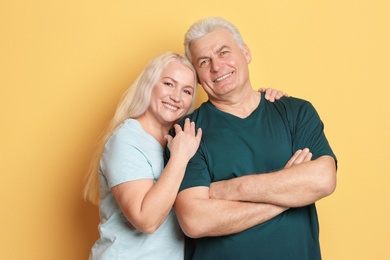 Portrait of adorable mature couple against color background