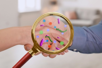 Image of Magnifying glass detecting microbes and business partners shaking hands, closeup