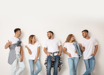 Group of young people in jeans on light background