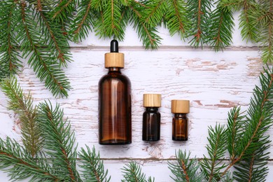 Flat lay composition with bottles of pine essential oil and conifer tree branches