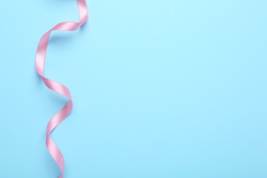 Photo of Beautiful pink ribbon on light background, top view. Space for text