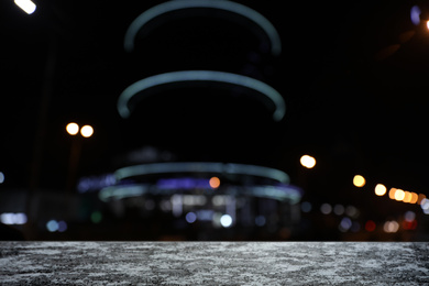 Empty stone surface and blurred view of night city