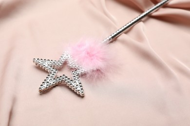 Beautiful silver magic wand with feather on pink fabric