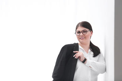 Beautiful overweight businesswoman posing on light background, space for text. Plus size model