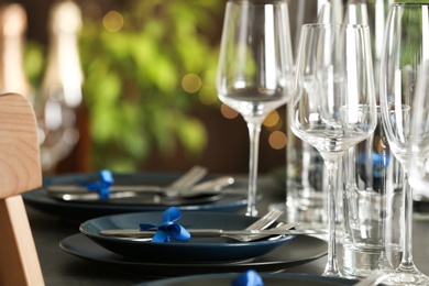Table setting with empty glasses, plates and cutlery indoors. Space for text