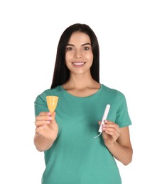 Young woman with menstrual cup and tampon on white background