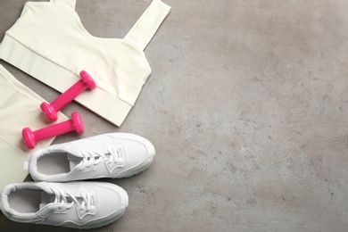 Flat lay composition with sportswear and equipment on grey table, space for text. Gym workout