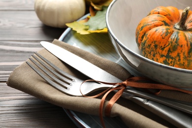 Festive table setting with pumpkins on wooden background, closeup. Thanksgiving Day celebration
