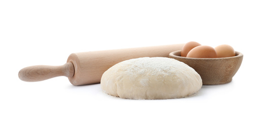Dough, eggs and rolling pin on white background. Cooking pastries