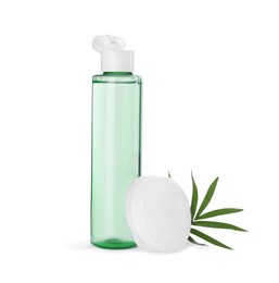 Bottle of micellar cleansing water, cotton pads and green twig on white background