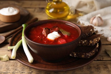 Clay bowl with Ukrainian borsch served on wooden table