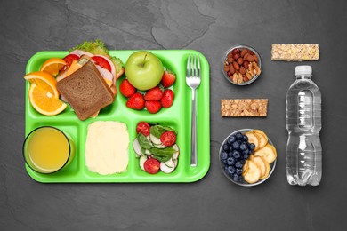 Flat lay composition with serving tray, tasty healthy food and bottle on grey table. School dinner