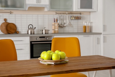 Photo of Table with ripe apples in stylish kitchen interior